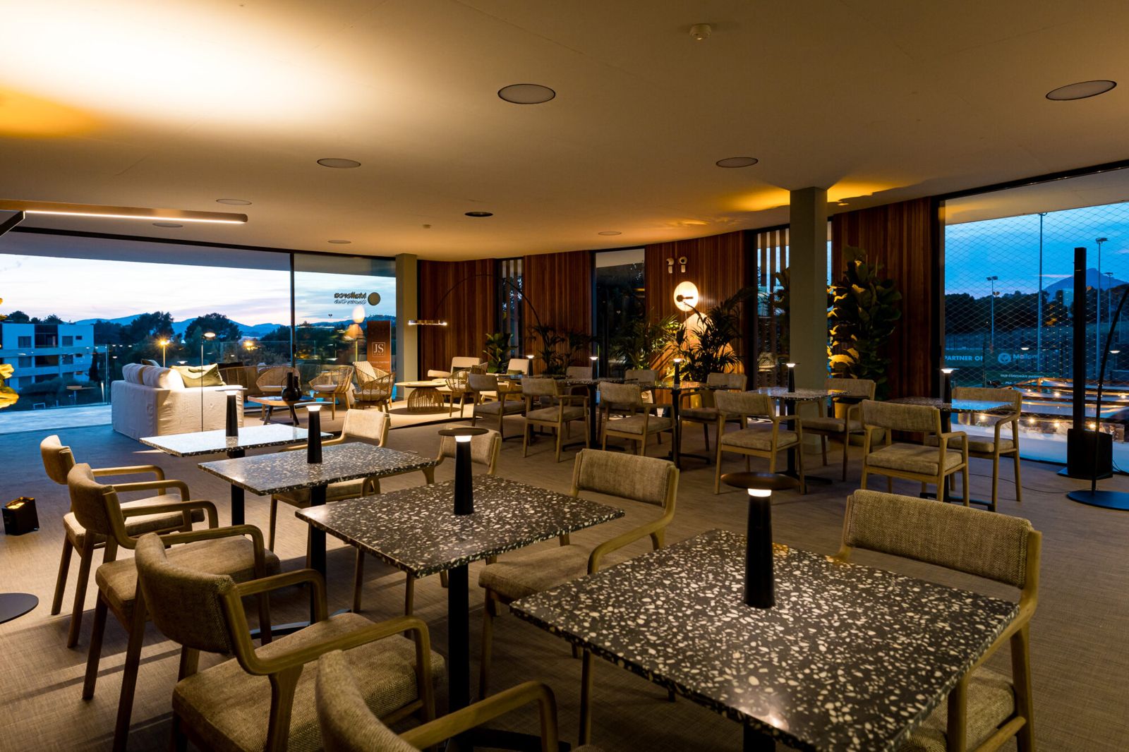 The clubhouse lounge with wooden chairs and terrazzo tables