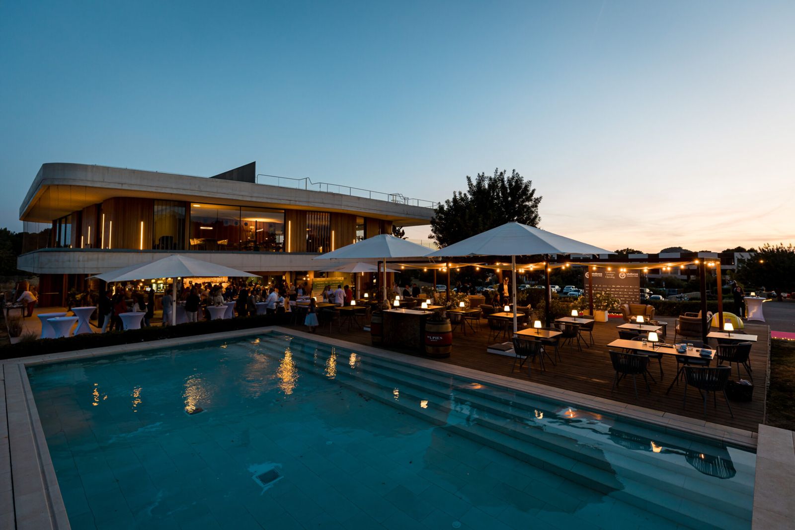 The club terrace and pool lit up at dusk
