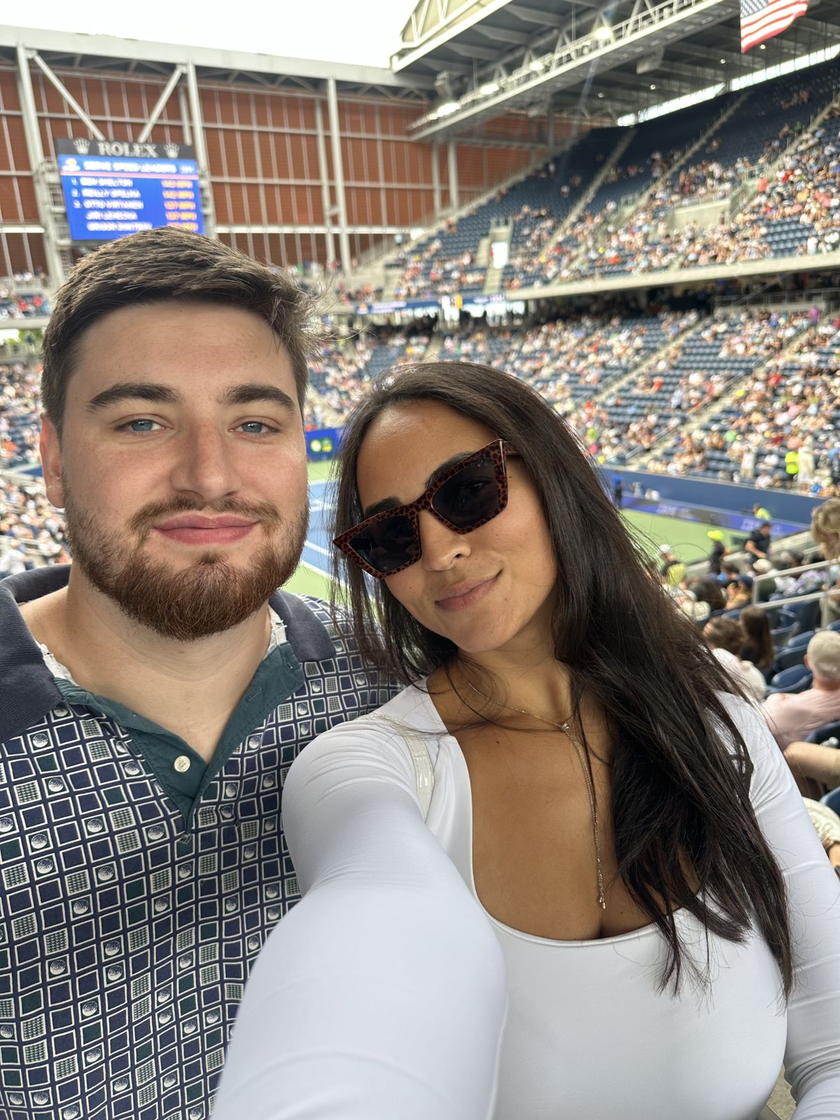 A selfie of the couple in the stands of a tennis stadium