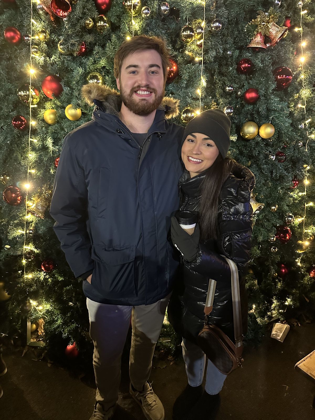 The couple in front of a decorated Christmas tree