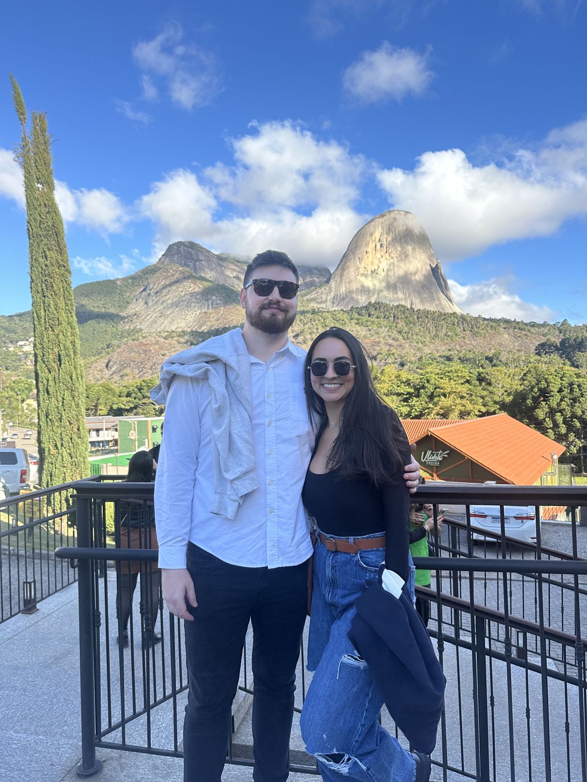 The couple at a viewpoint with mountains behind