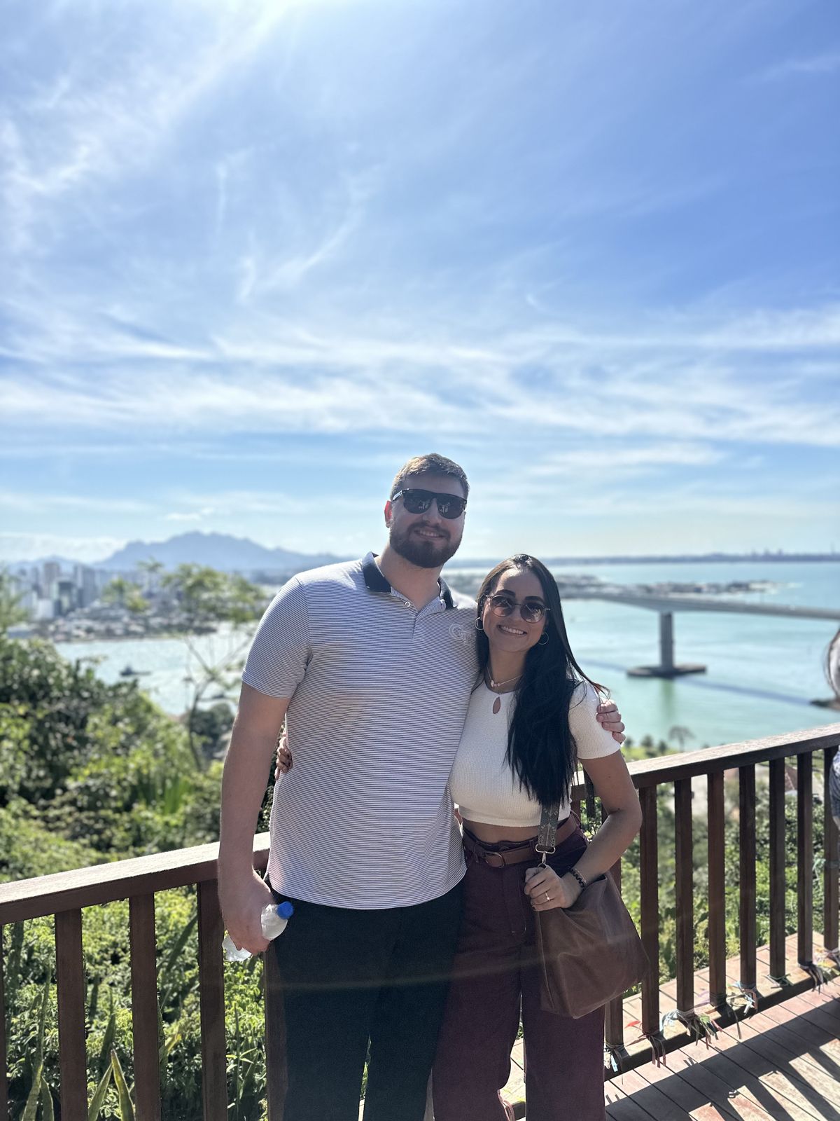 The couple on a balcony above a bay