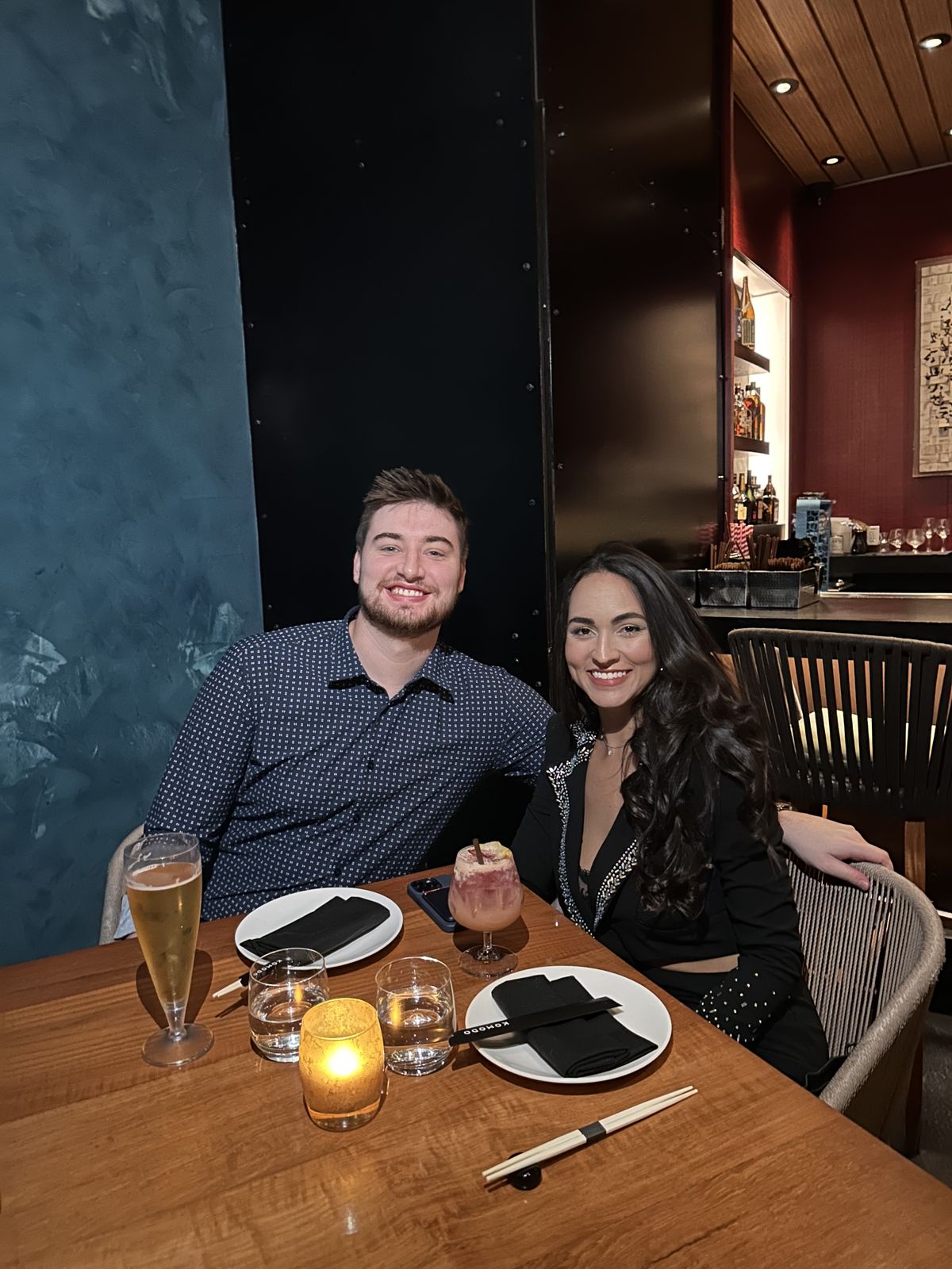 The couple smiling at a candlelit dinner table