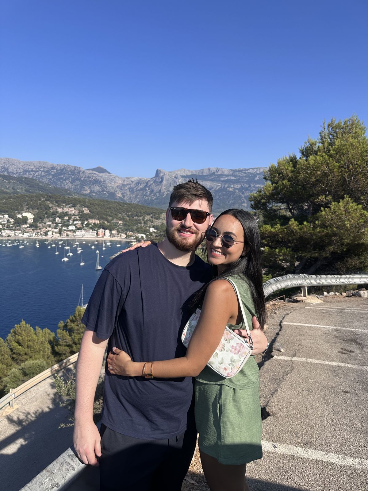 The couple at a viewpoint over a bay and mountains