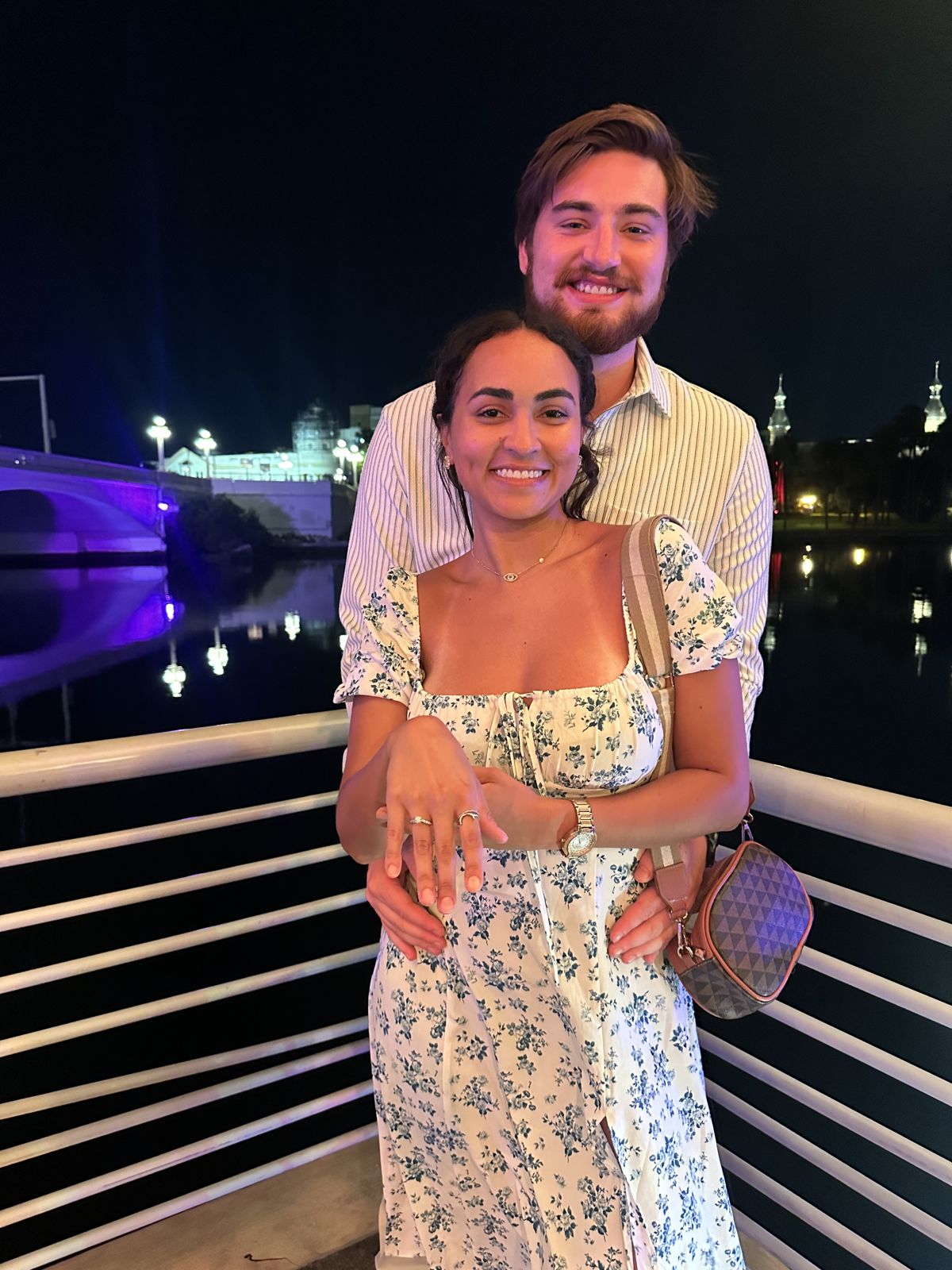The couple hugging by the water at night